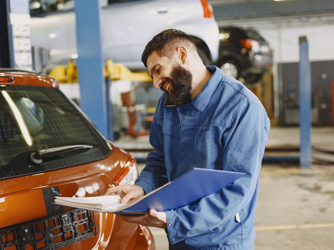 A shop owner reviewing expansion plans on a tablet inside a modern service facility