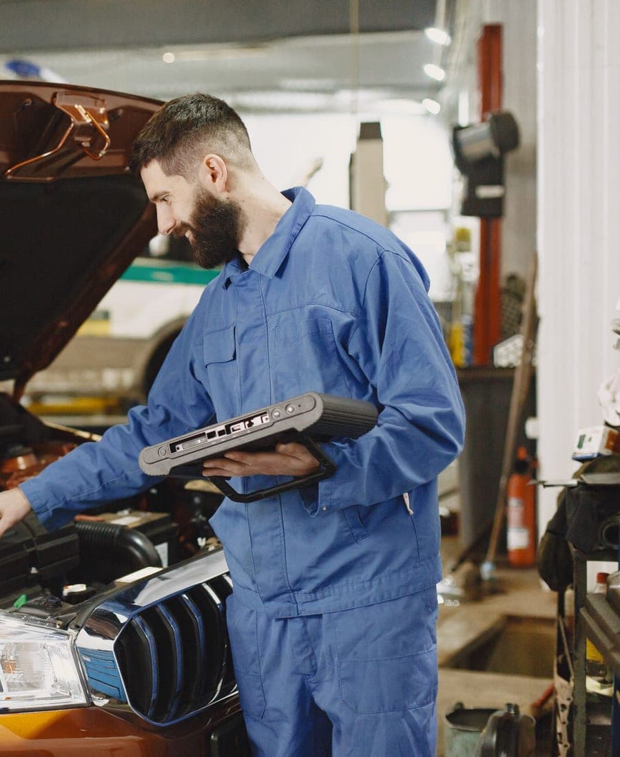 Technician running diagnostics on an engine with a handheld scan tool